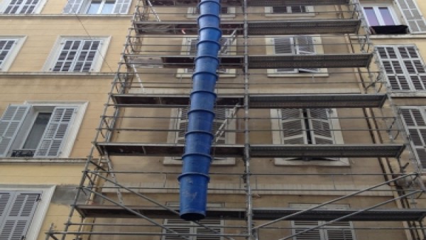 pose de goulotte de chantier sur la facade de l'immeuble
